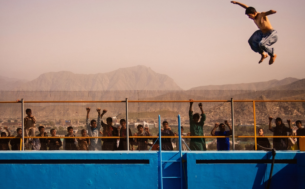 Ein afghanischer Mann springt von einem Sprungbrett in ein Schwimmbecken auf einem Hügel über Kabul,Afghanistan, am 17.Mai 2013