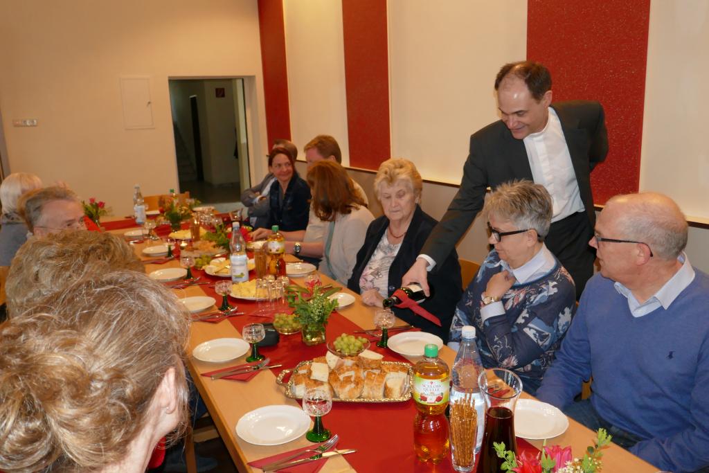 Pfarrer Schmitz schenkt bei der Agape-Feier den Wein ein