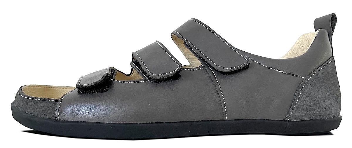 Herren Sandale aus grauem Leder mit weißen Nähten mit Fersenriemen und Klettverschlüssen. Mit Lederinnenfutter Beige und schwarzer Sohle.