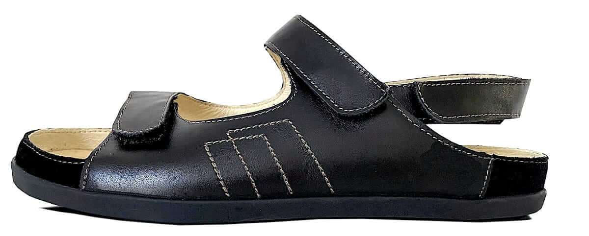 Herren Sandale aus schwarzem Leder mit weißen Nähten mit Fersenriemen und Klettverschlüssen. Mit Lederinnenfutter Beige und schwarzer Sohle.