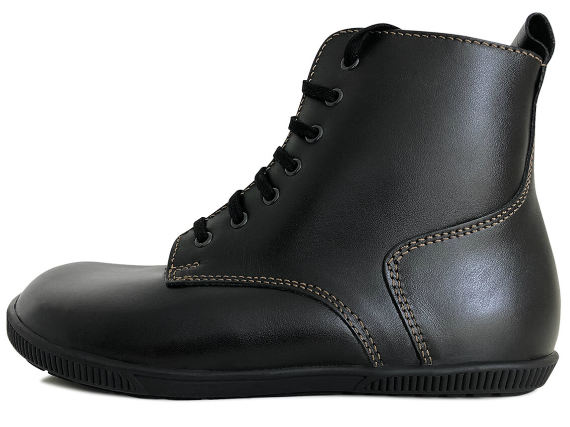 Barfußschuh als Winterstiefel aus schwarzem Glattleder mit camelfarbenen Nähten und grob profilierter Sohle, schwarzen Senkeln und schwarzen Lammfell