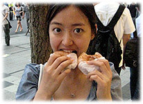 Picture of a young Korean woman eating donuts - Bild einer jungen Koreanerin beim Donuts essen