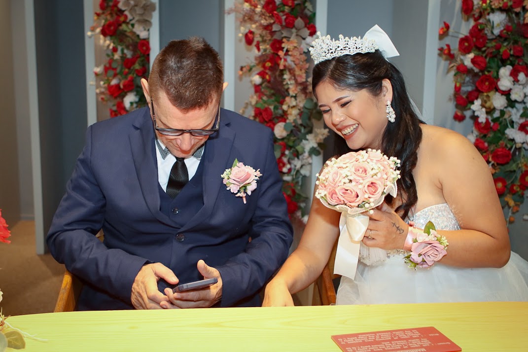 Hochzeitspaar unterschreibt Heiratsurkunde