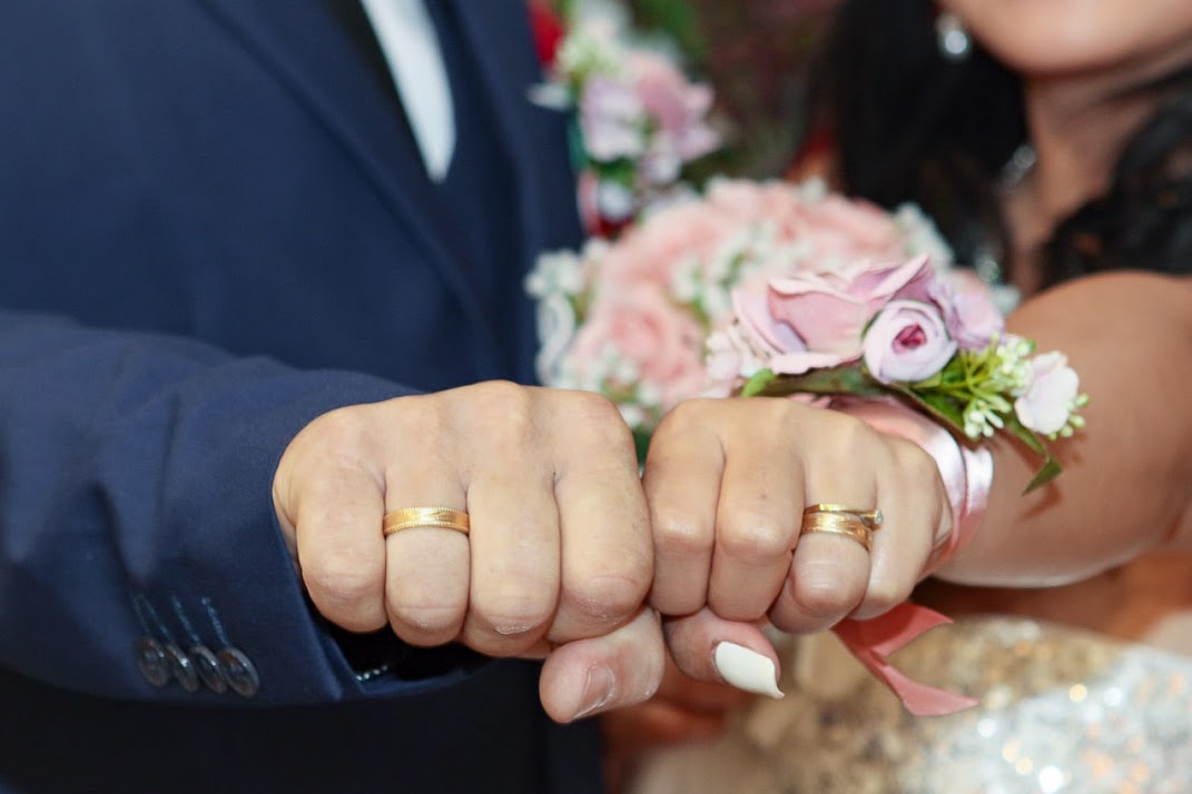 Hochzeitspaaar mit Brautstrauss und Eheringen