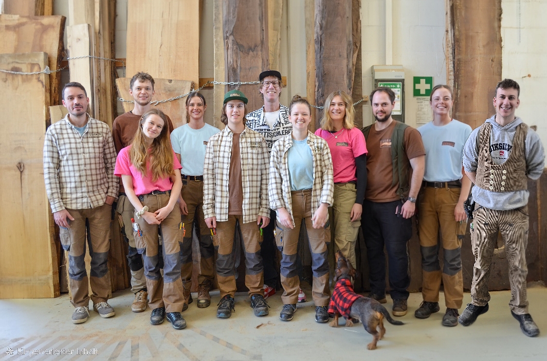 Blick in die Werkstatt einer Tischlerei, Bild mit allen Team Mitglieder*innen in der Werkstatt