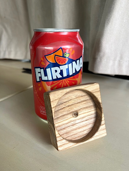 Rustikaler Dosendeckel aus einem Holzwürfel, lehnt neben der Dose