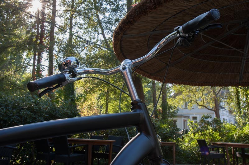 Foto : Andreas Hartwig, Bild zeigt einen Fahrradlenker unter einem Sonnenschirm vor dem Graftwerk  in den Delmenhorster Graftanlagen, Fahrrad von Zweirad-Kehlenbeck, Delmenhorst, Bildstrecke "unterwegs in Delmenhorst"