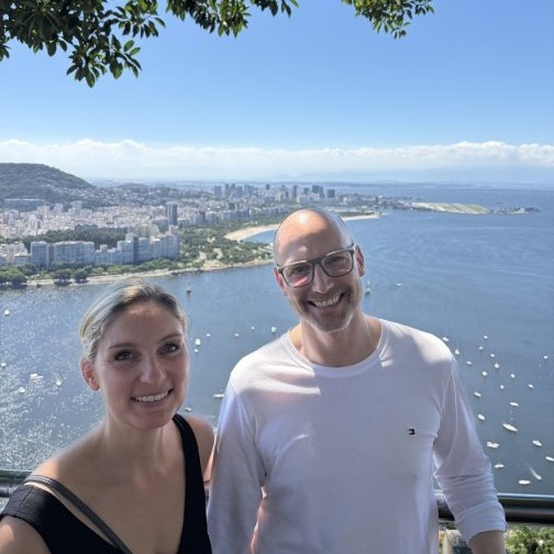 Zwei Erwachsene vor einer Bucht von Rio de Janeiro