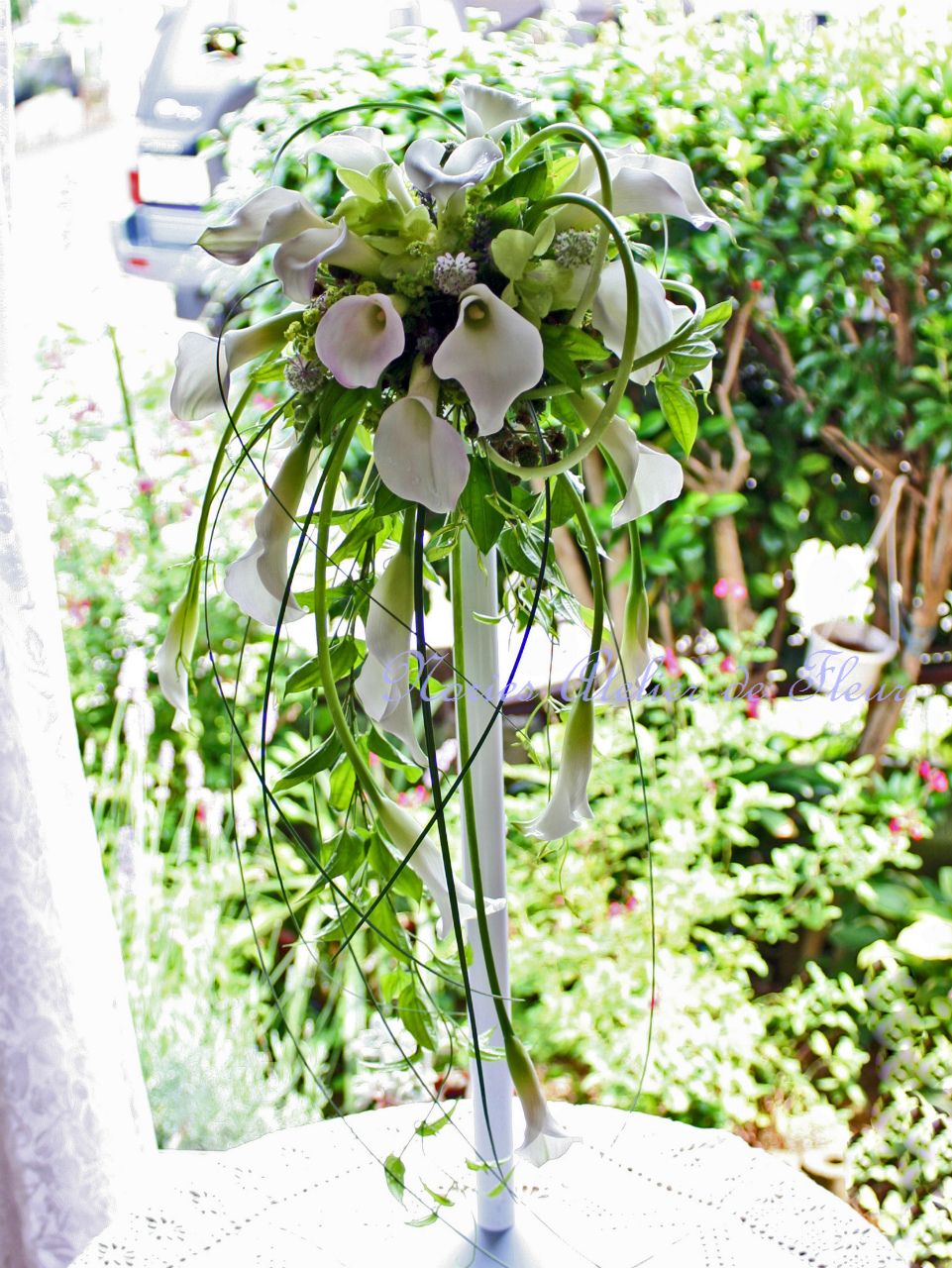 生花の白いバラ、カラーとグリーンのデンファレのキャスケードブーケ