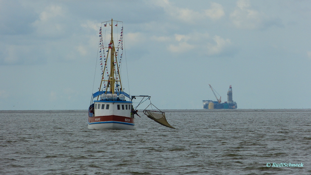 rechts neben dem Fischerboot ist die Ölbohr- und Förderinsel "Mittelplate" zu sehen.