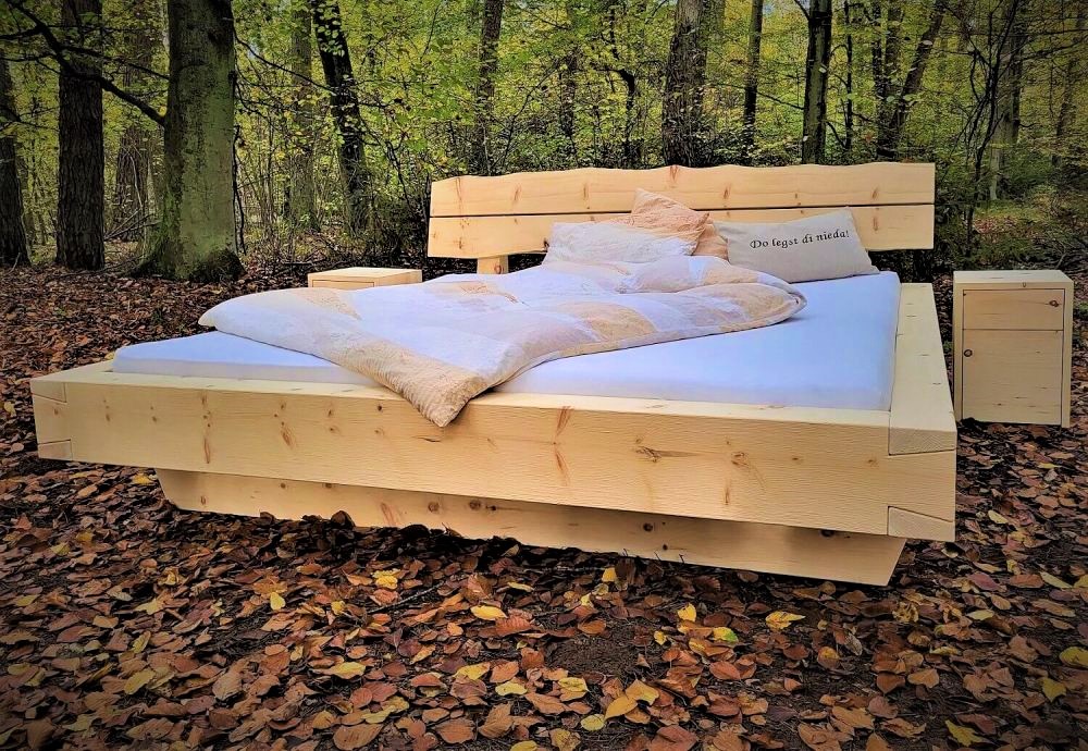 Zirbenholzbett aus Balken im Wald mit Nachttische