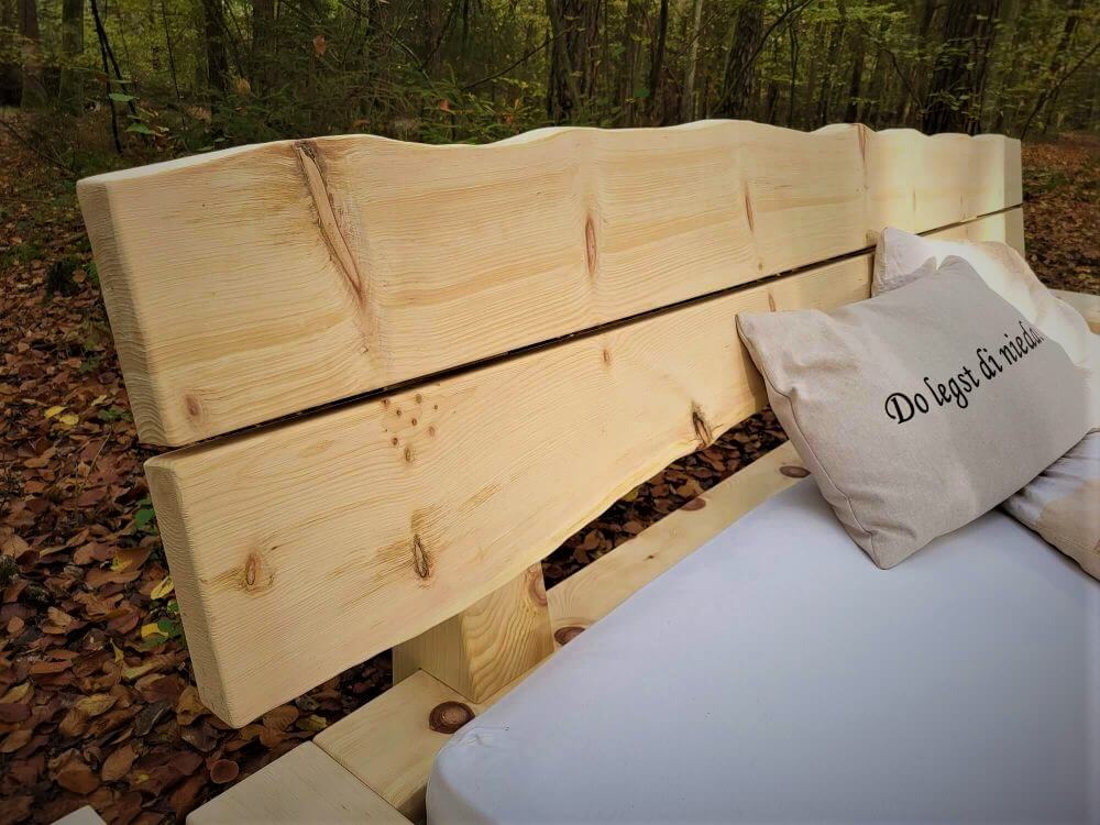 Kopfteil mit Baumkante am massiven Balkenbett aus Holz