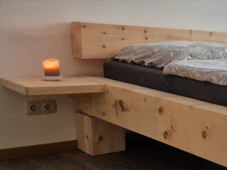 Ablagebrett in Zirbe am Bett montiert