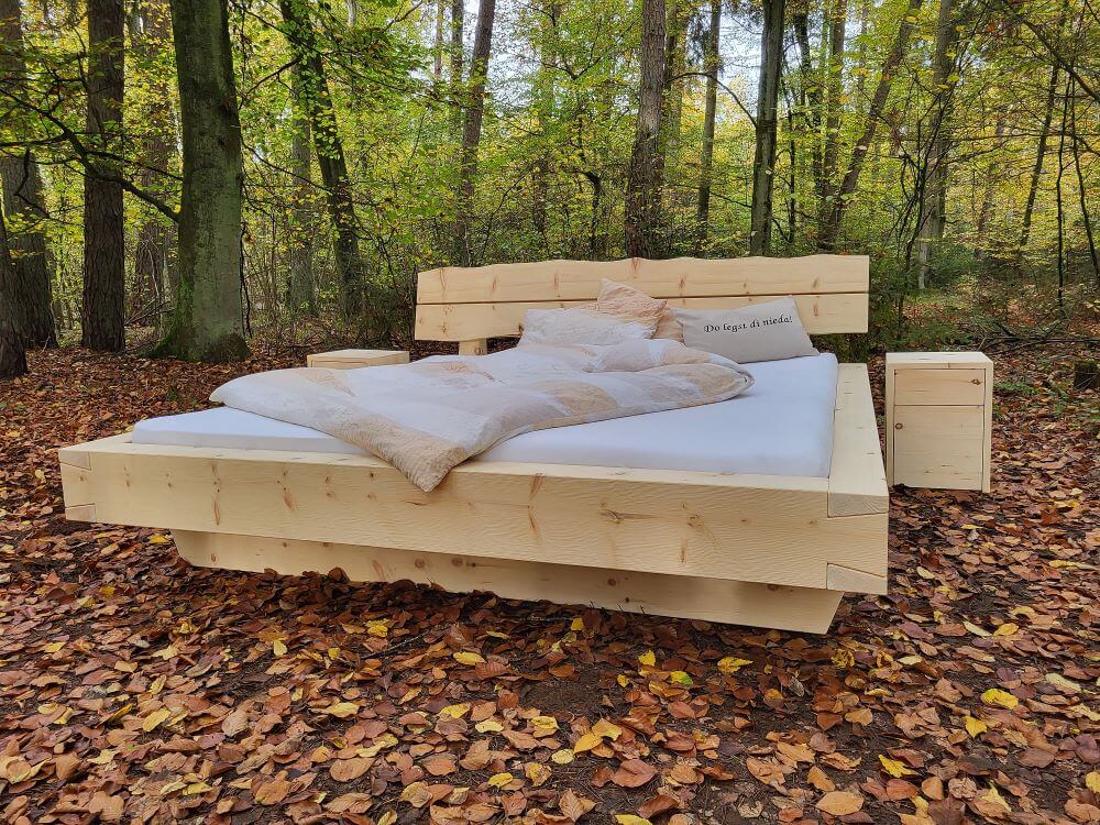 Zirbenholzbett aus massivem Holz mit naturbelassener Oberfläche, gefertigt in traditioneller Schreinerarbeit.