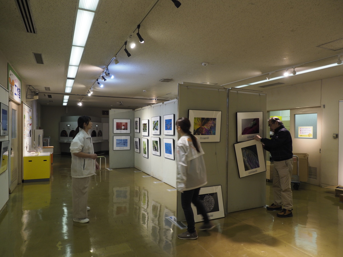 展示中の写真と、展示準備中の館の方々です。ご苦労さまでございます。