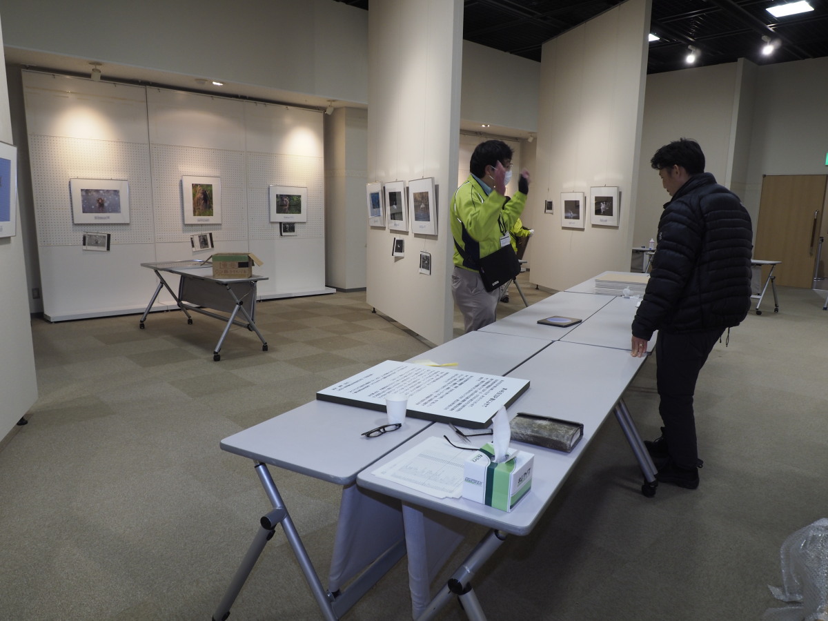 写真パネルを箱から取り出して、額装や壁面展示の準備を行っていただいている館の方々です。毎年のことながら、お疲れさまでございます。