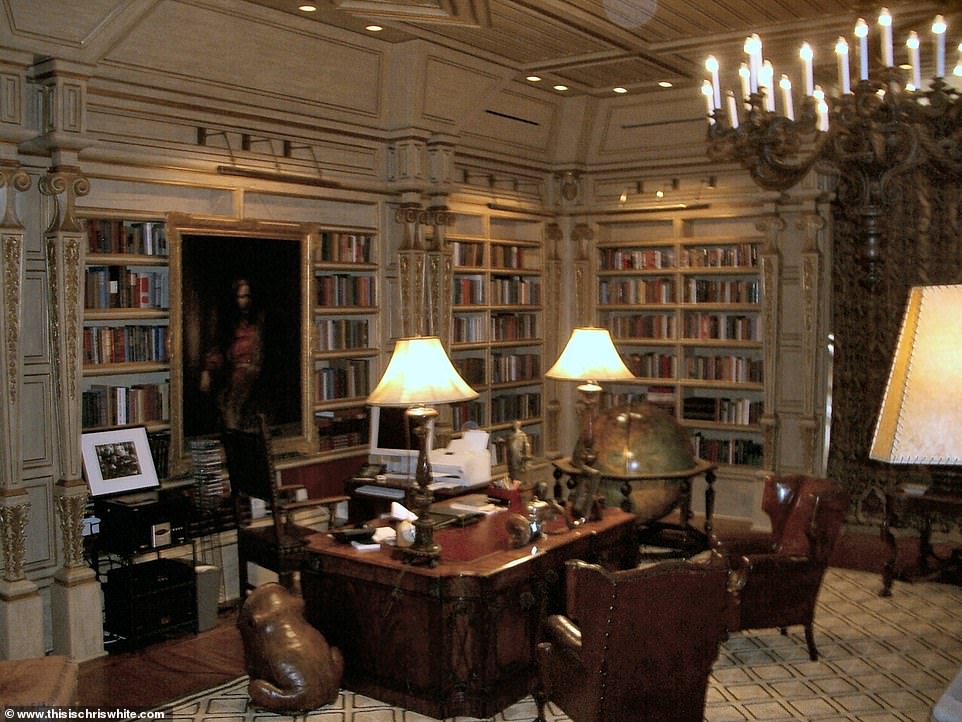 La bibliothèque regorge de grands meubles anciens, notamment des lustres gothiques et des chaises en cuir métallique