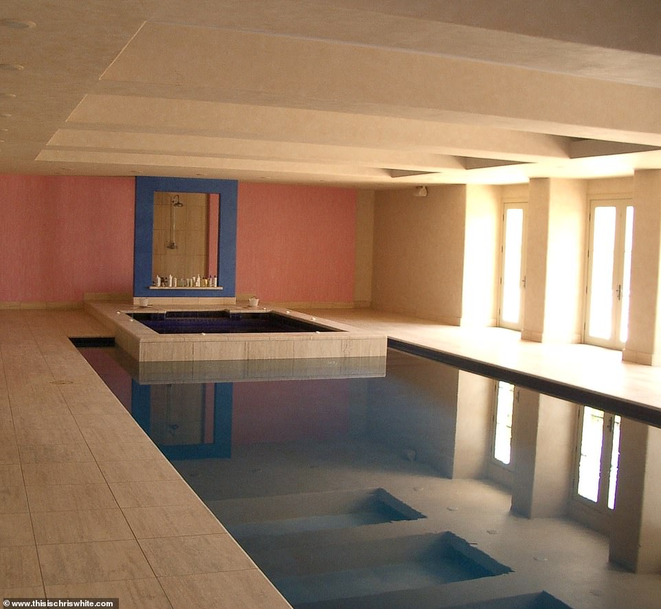 La grande zone de baignade intérieure comprend une piscine surdimensionnée, un bain à remous et une douche encadrée derrière