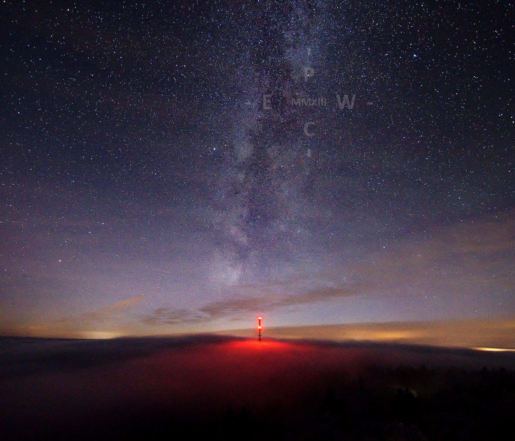 Milchstraße über dem aus dem Nebel ragendem Fernsehturm am Großen Waldstein im winterlichen Fichtelgebirge