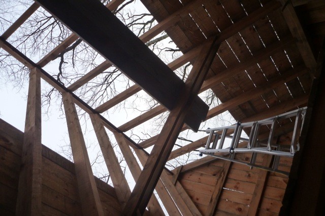 The roof sheathing is pulled off, exposing the rafters