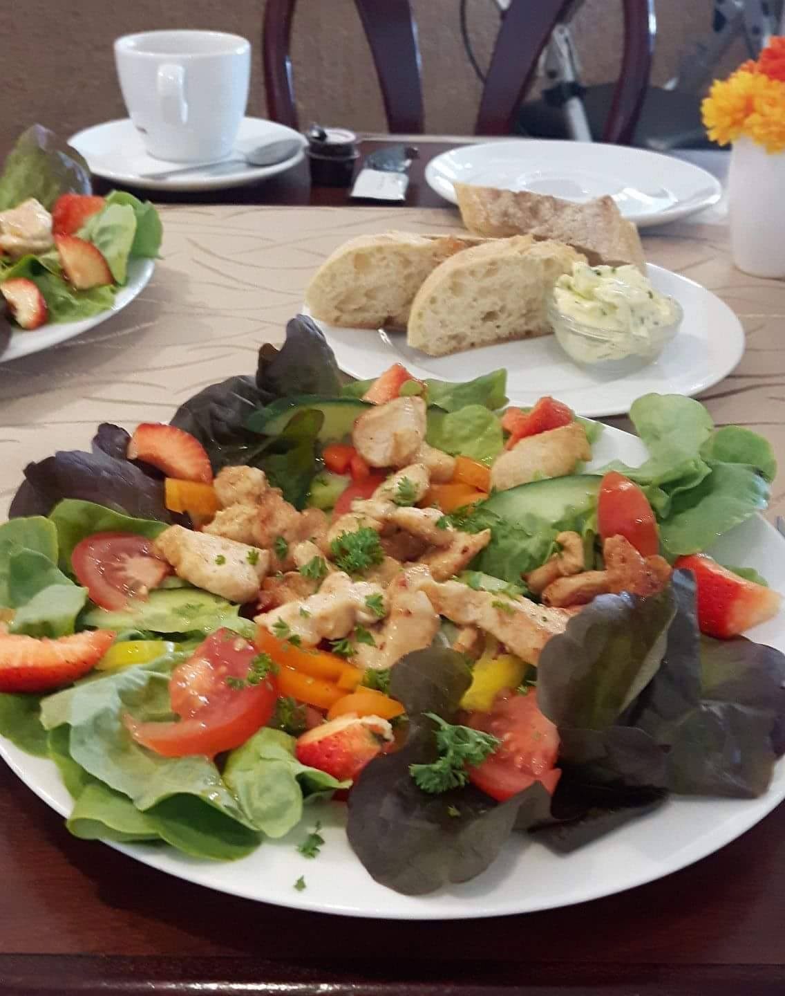 Salatteller mit Hühnchen-Bruststreifen, Brot und Kräuterbutter
