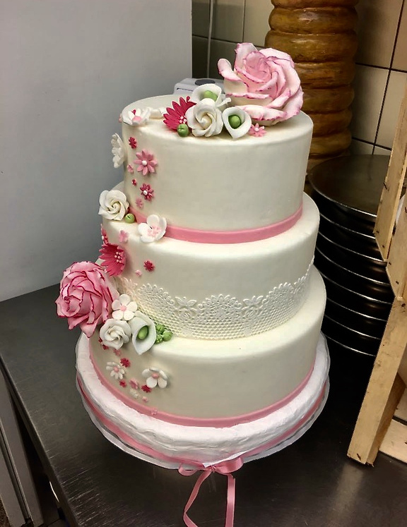3stöckige Torte in weißem Fondant mit rosa Fondantblumen