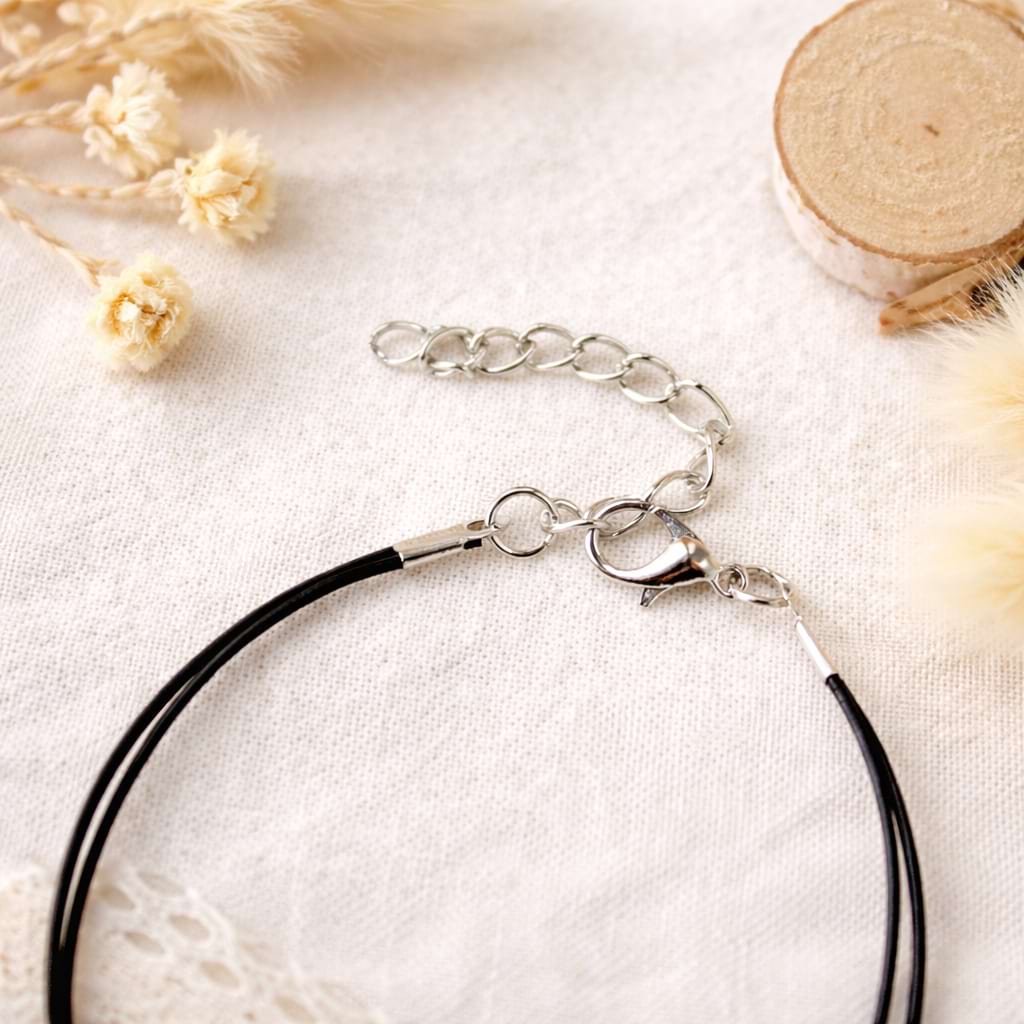 Nahaufnahme eines schwarzen Schmuckbands mit Karabiner und Verlängerungskette.