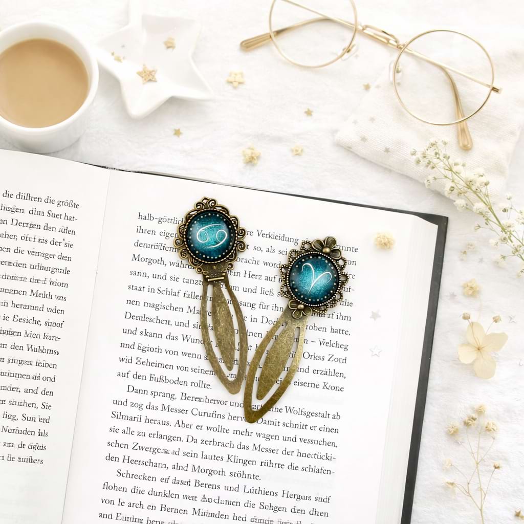 Offenes Buch mit zwei blauen Sternzeichen‑Lesezeichen, Kaffee, Brille und Deko – gemütliche Leseecke.