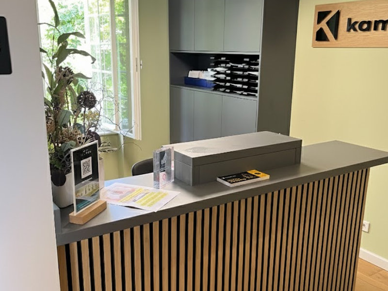 Schlanker Empfangstresen in warmer Holzoptik für Praxisrezeptionen