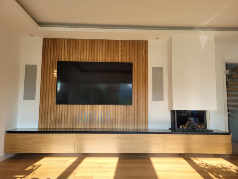 Schwebendes TV-Sideboard mit vertikaler Holzrückwand als Akustikpaneel