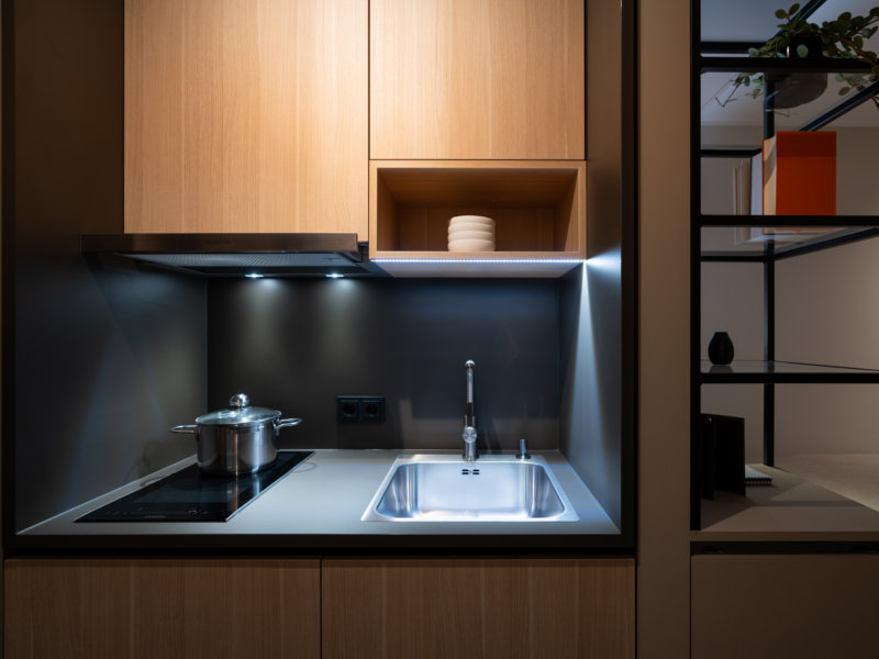 Kompakte Küchenzeile im Mini-Apartment mit clever genutztem Stauraum