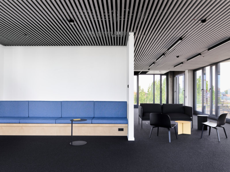 Großzügiger Loungebereich: Blaue Sitzbank mit integriertem Holzpodest 