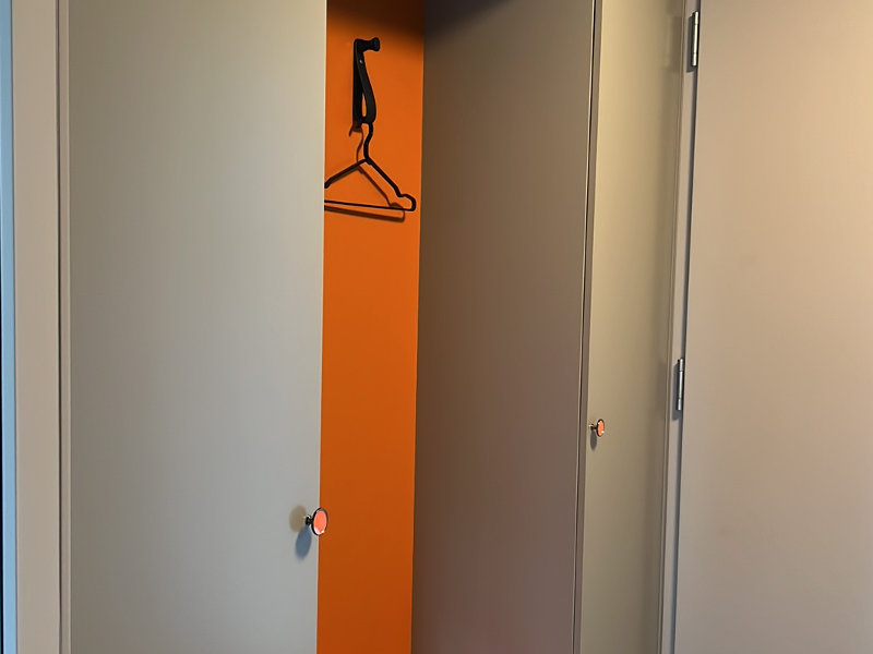 Geräumige Garderobe mit orangener Sitznische und viel Stauraum