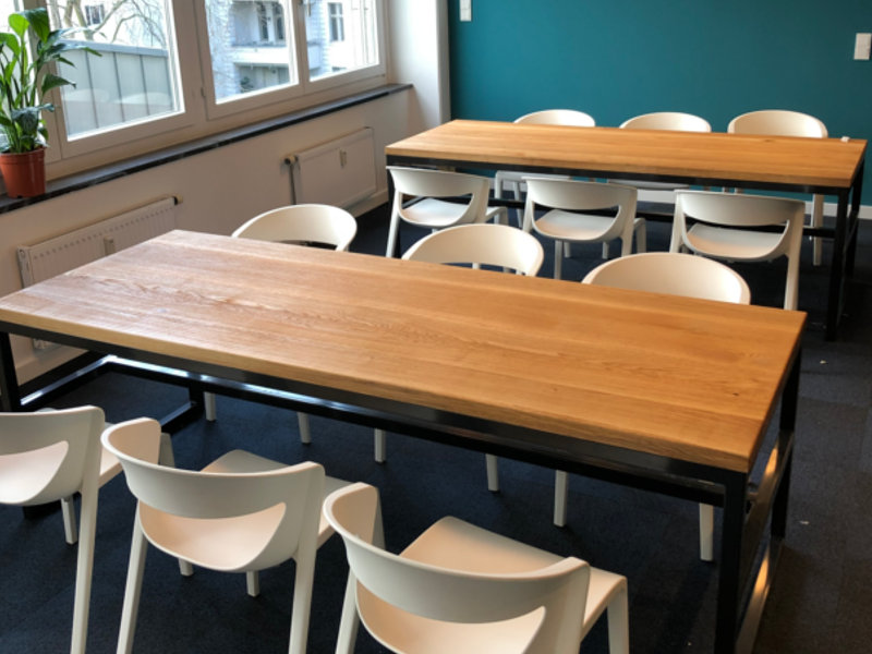 Offener Essbereich mit langen Holztischen: Geräumige Lounge mit Sitzgruppen