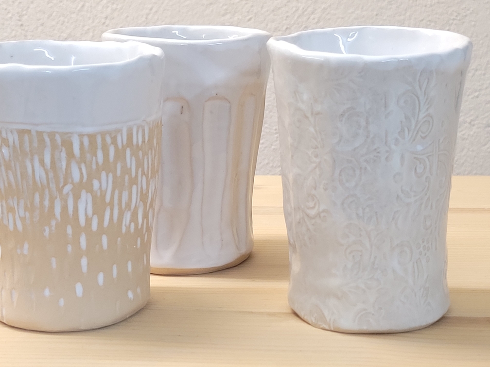mehrere Becher in beige-weißer Optik mit Strukturen