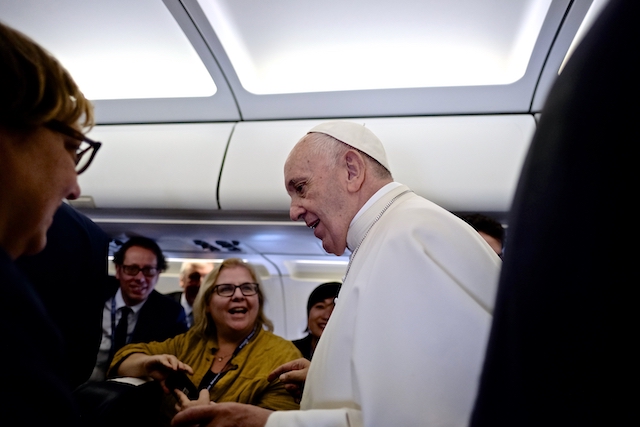 The Pope is going back to his seat for the landing in Geneva.
