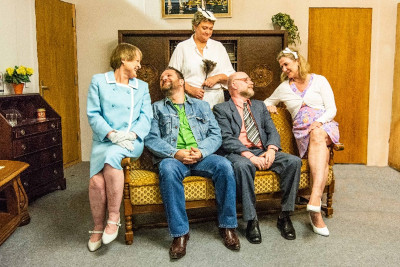 Fünf Schauspieler und Schauspielerinnen in einem Bühnenbild auf einem alten Sofa