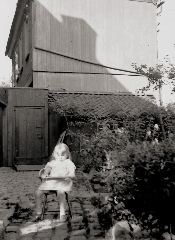 Bettina Heinen-Ayech, enfant, dans la cour de la maison de ses parents à Solingen - à l'arrière-plan, la "Maison rouge", photo datant de 1939.
