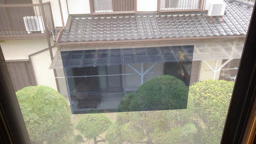 2階の窓にカットしたフイルムをテスト貼り　向こう側に隣の家