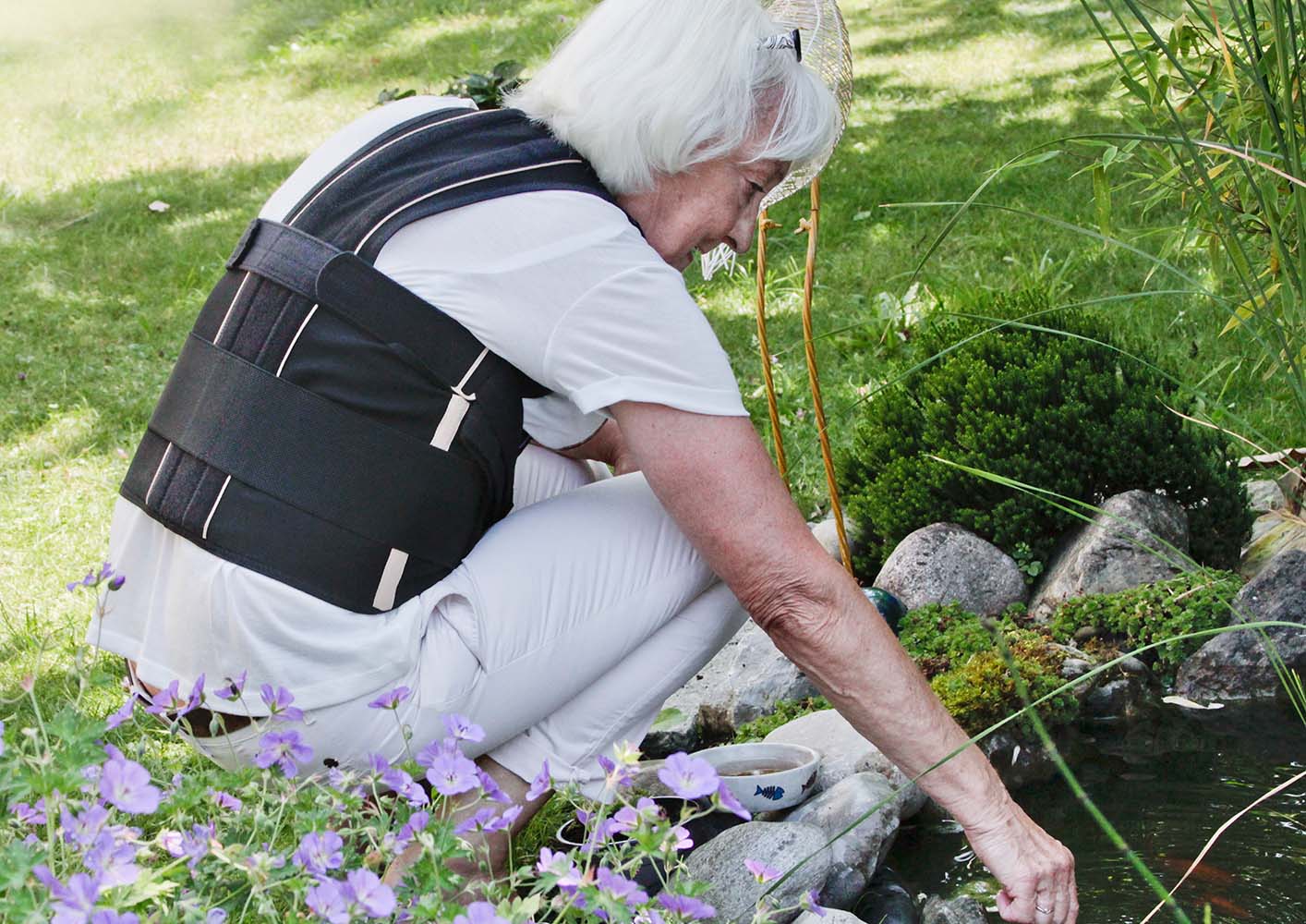 Frau bei der Gartenarbeit trägt das 3tlg.Rückenbandagenset