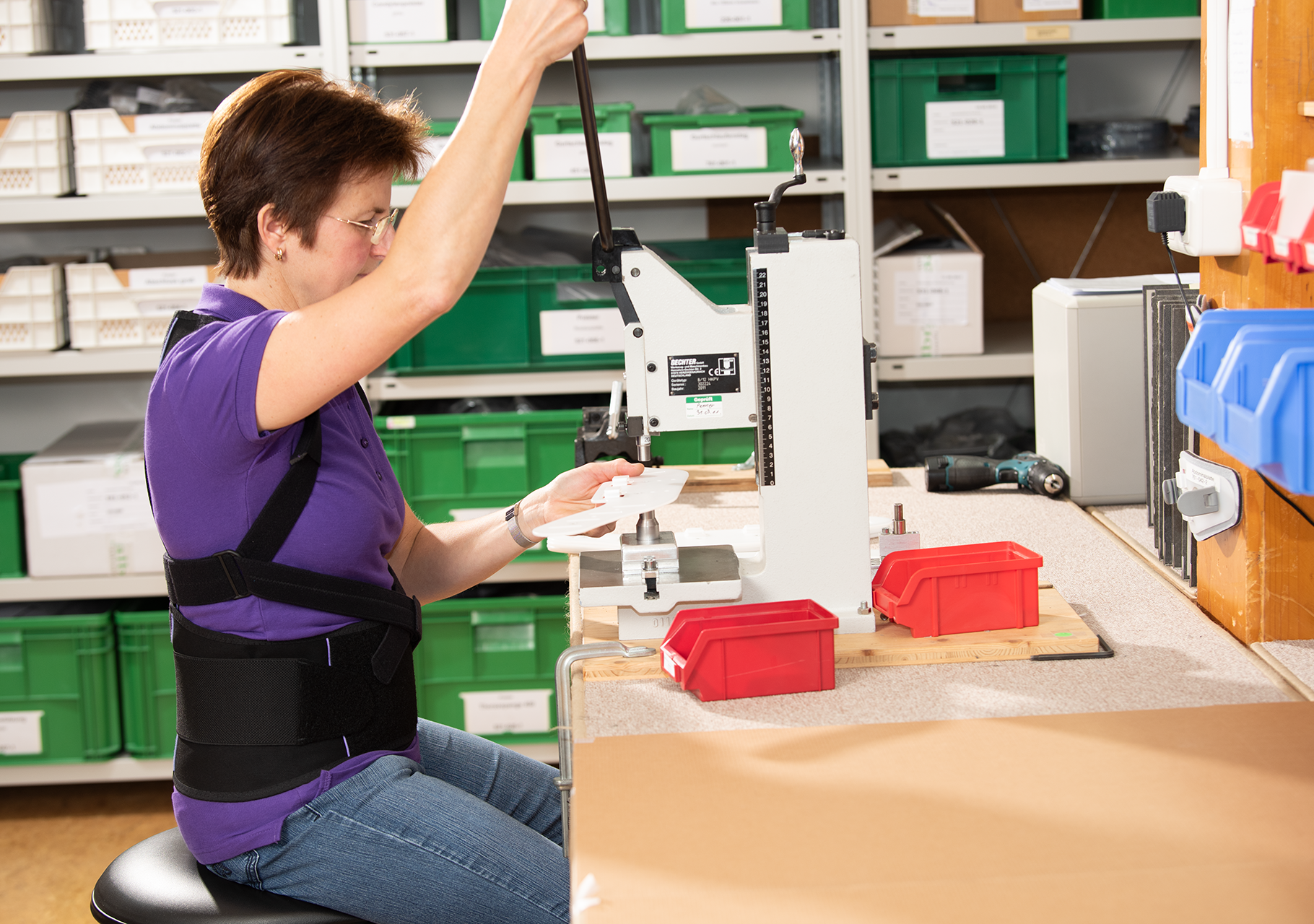 Frau arbeitet in der Produktion trägt das 3tlg. Rückenbandageset