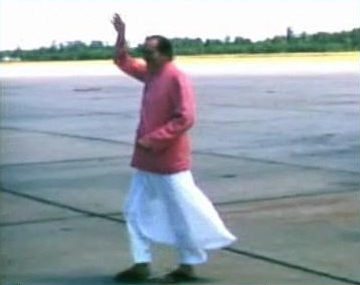 1956 : Meher Baba walking across the tarmac at Wilmington Airport, NC., after arriving from New York, on his way to Myrtle Beach, SC. Image captured by Anthony Zois from a film by Sufism Reoriented.