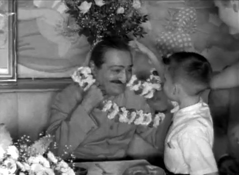 Meher Baba being garlanded by Larry Karrasch at Longchamps Restaurant, New York City, 22nd July 1956