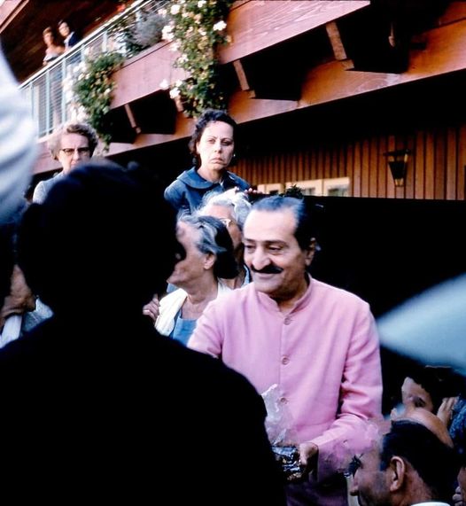 1958 : Meher Baba handing out prasad sweets to his followers, with Adele in the background.