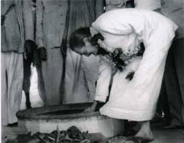 Meher Baba lighting the dhuni fire