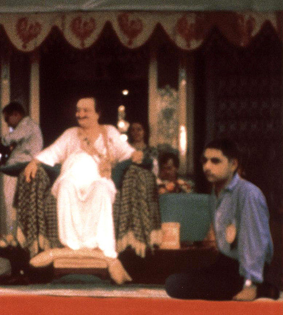 Naosherwan seated at Baba's feet at a darshan programme in India