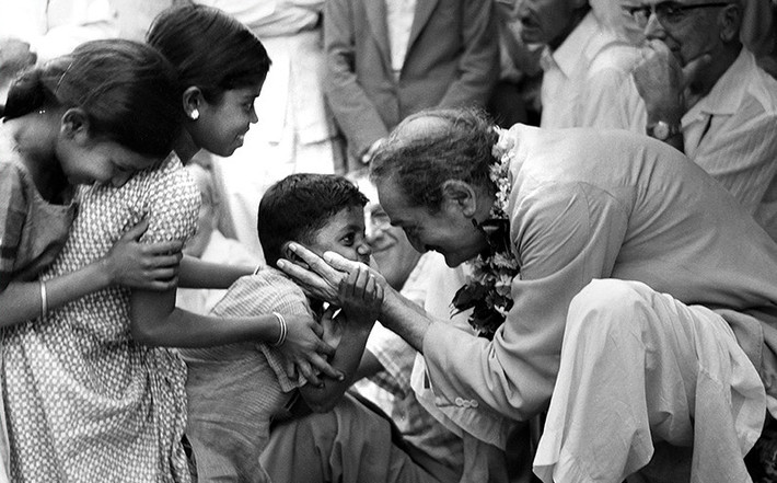 Baba holding Panday's nephew - Suresh Panday during the darshan program