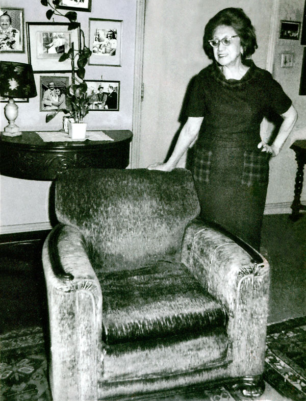 Hilda Fuchs in her Hollywood residence standing beside the chair in which Baba sat during His visit in 1956 -Lord Meher online - p.4056