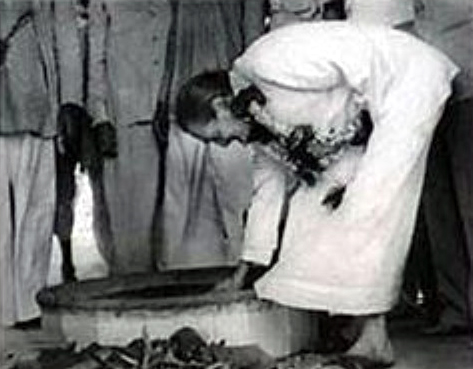 Meher Baba lighting the Dhuni