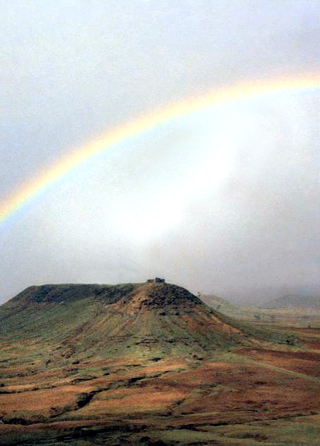Rainbow over Khandoba Hill near Meherazad, India - Photographed by Bill Reading